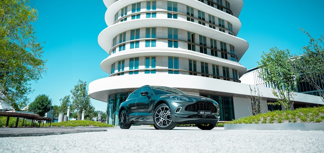 An electric car parked outside a modern hotel
