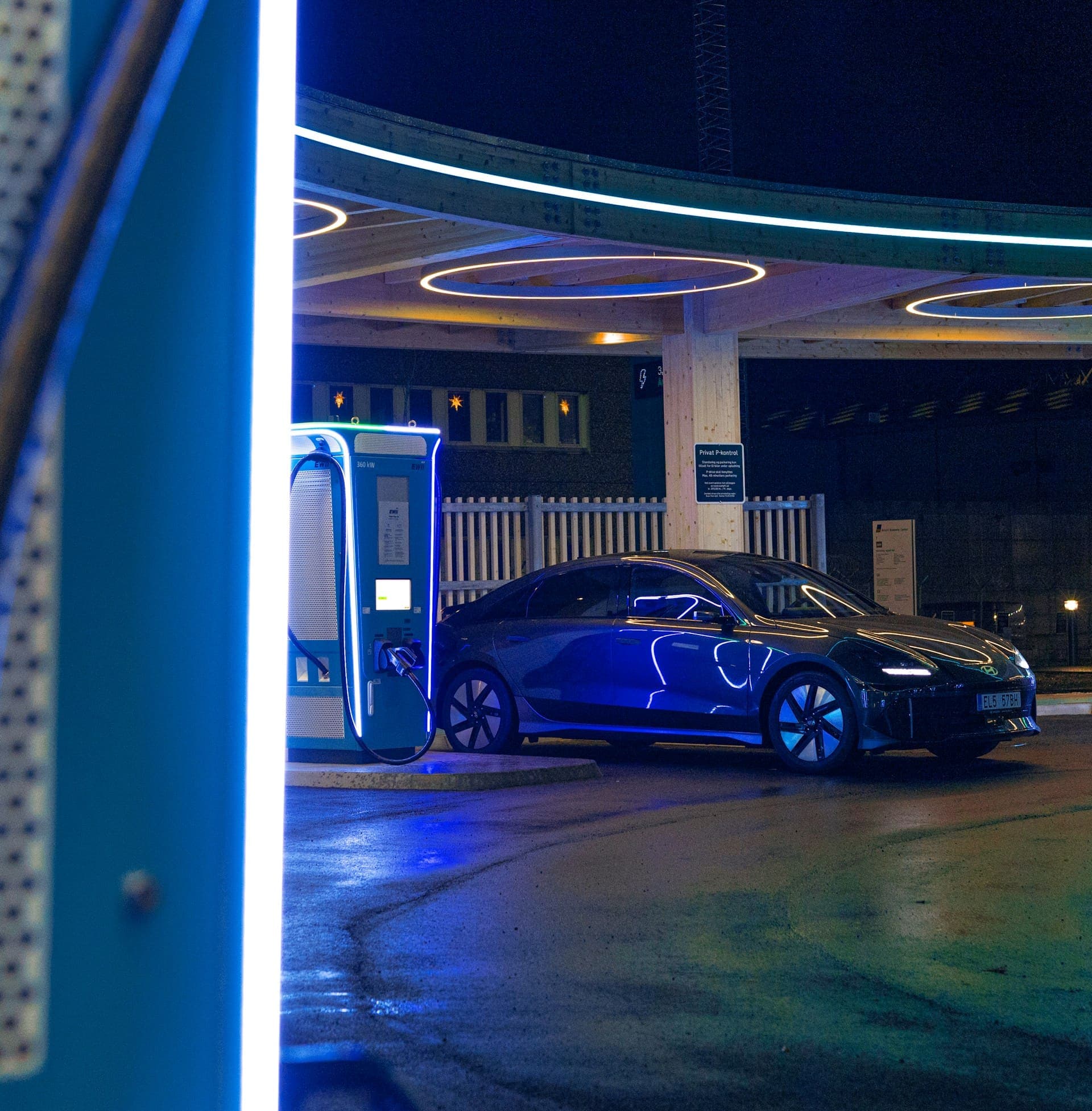 EV charging at a neon-lit fast-charging station at night